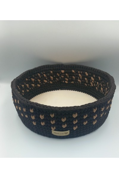 Στρογγυλό χειροποίητο καλάθι σε καφέ-μπεζ χρωματισμούς.