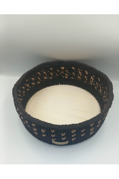 Στρογγυλό χειροποίητο καλάθι σε καφέ-μπεζ χρωματισμούς.