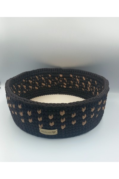 Στρογγυλό χειροποίητο καλάθι σε καφέ-μπεζ χρωματισμούς.