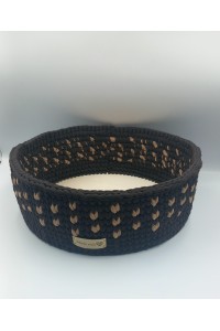 Στρογγυλό χειροποίητο καλάθι σε καφέ-μπεζ χρωματισμούς.